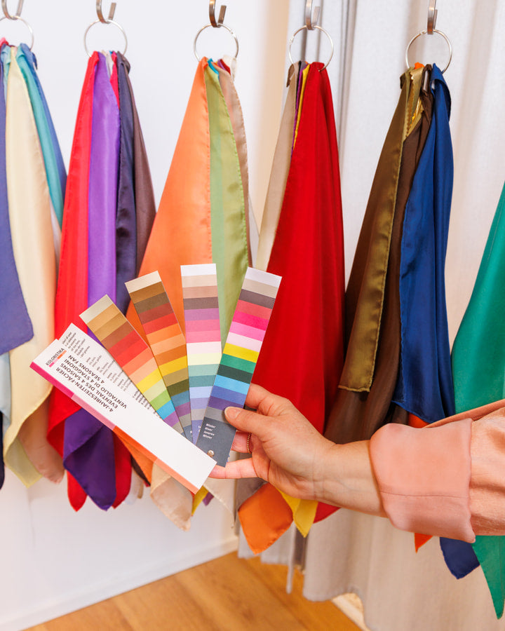 Nuancier de colorimétrie tenu devant des foulards colorés